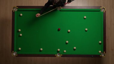 Hobi ve eğlence konsepti. Lüks bilardo kulübü sahnesi. Beyaz topların etrafa saçıldığı Rus bilardo masasının tam görüntüsü. Bilardo ıstakasını tebeşirle cilalayan kişi..