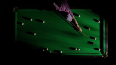 Hobi ve eğlence konsepti. Lüks bilardo kulübü sahnesi. Rus bilardo masasının üst görüntüsü net cebi ve içine düşen beyaz top, deliğin içindeki topa vuran kişi..