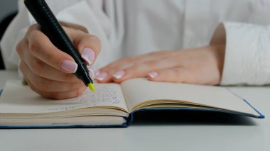 Kağıt üzerinde öğrenci el cevap sınavı. Masadaki kadının önemli bir sınav belgesiyle çalışırken, öğrencinin sınavda okuyup cevap alırken, işaretli harflerle soru işaretleri çizerken yakın plan fotoğrafını çek..