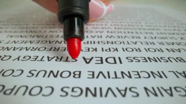 Kadın eli kağıtta bir kelimeyi vurguluyor. Kadın elinin belgeyle çalışırken yakın plan çekimleri, kadın elinin kırmızı işareti, ünlem işaretli bir kelime fikrini daire içine aldı..