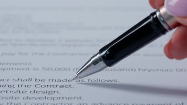 Kağıt üzerinde kalemle kadın el yazısı. Kadın elinin belgeyle çalışırken yakın plan resmi, kadın elinin kalemle finansal veya iş belgesinde kişisel bir imza yazarken..