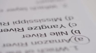 Üniversitede ya da okulda sınava giren kişi. Dişi çemberler, standart sınav kağıdında siyah kalemle doğru cevaplar veriyor. Öğrenci cevap kağıdını dolduruyor, doğru cevabı seçiyor, makro çekim.