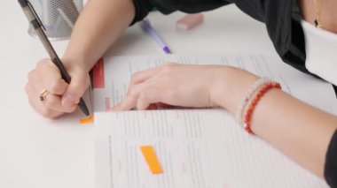 Üniversitede ya da okulda sınava giren kişi. Standart sınav kağıdında renkli bantla kitap ayracı yapan bir kadın. Çalışan günlüğe yer imleri için bant sekmesi yapıştıran öğrenci.