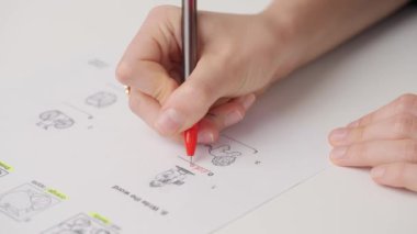 Üniversitede ya da okulda sınava giren kişi. Dişi çemberler kırmızı kalemle standart sınav kağıdında doğru cevaplar verir. Cevap kağıdını dolduran öğrenci, doğru cevabı seçiyor, yakın çekim.