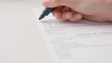 Bayan öğretmen ödevler için not veriyor. Profesyonel okul ya da üniversite öğretmeni öğrencilerin ödev sınav kağıtlarını not eder. Kadın test sonuçlarında doğru cevaplar için yeşil işaretli işaretler çizer.