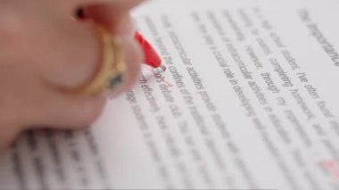 Bayan öğretmen ödevler için not veriyor. Profesyonel okul ya da üniversite öğretmeni öğrencilerin ödev sınav kağıtlarını not eder. Kadın kompozisyonu kontrol ediyor ve yanlış kelimeyi geçiyor, kırmızı kalemle düzeltiyor..