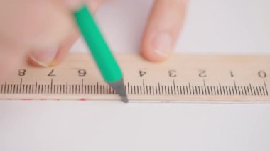 Üniversitede ya da okulda sınava giren kişi. Kadın, geometri sınav kağıdında kalem ve cetvelle doğru cevabı çizer. Cevap kağıdını dolduran öğrenci, yakın çekim..