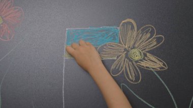 Anaokulu derslerini ziyaret eden bir grup çocuk. Gelişim derslerinde yaratıcı görevler yapan çocuklar, renkli tebeşirlerle karatahtaya resim çiziyorlar. Çocuk eğitimi konsepti.