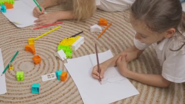 Anaokulu derslerini ziyaret eden bir grup çocuk. Genç öğretmen ve bir grup çocuk renkli kalemlerle çizerek gelişim derslerinde yaratıcı işler yapıyorlar. Çocuk eğitimi konsepti. Yavaş çekim.