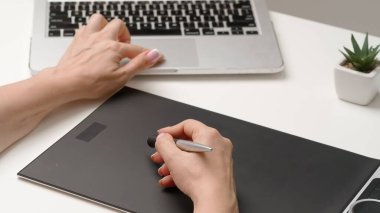 Tablet ve kalem kullanan kadın tasarımcı çizer. Kadın grafik tasarımcısı dijital grafik tablet üzerinde çalışıyor masasında stilus, el çizimi yaratma ve çizim. Yaratıcılık ve modern teknoloji.