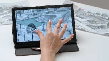 Tablet ve kalem kullanan kadın tasarımcı çizer. Kadın mimar tasarımcı, şehir parkının el boyama projesi Stylus ile birlikte grafik tablet sergisinde çalışıyor. Yaratıcılık ve modern teknoloji.