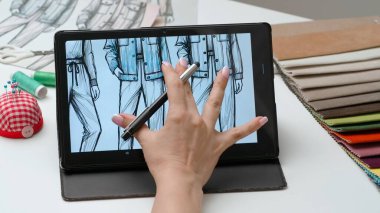 Tablet ve kalem kullanan kadın tasarımcı çizer. Kadın moda tasarımcısı dijital grafik tablet dokunmatik ekranda kıyafet koleksiyonu çizimi ile çalışıyor. Yaratıcılık ve modern teknoloji.