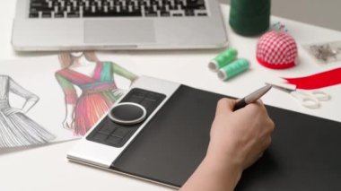 Tablet ve kalem kullanan kadın tasarımcı çizer. Kadın moda tasarımcısı stilus ile dijital grafik tablet üzerinde çalışıyor, kadın kıyafetleri çizimi resim projesi. Yaratıcılık ve modern teknoloji.