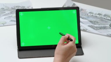 Tablet kullanan kadın tasarımcı çizer. Kadın mimar tasarımcı grafik tablet, krom anahtar yeşil ekran arkaplan, çalışma alanı modeli üzerinde çalışıyor. Yaratıcılık ve modern teknoloji.
