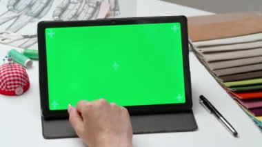 Tablet kullanan kadın tasarımcı çizer. Kadın moda tasarımcısı grafik tablet, krom anahtar yeşil ekran arka planı, çalışma alanı modeli üzerinde çalışıyor. Yaratıcılık ve modern teknoloji.