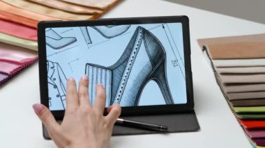 Tablet ve kalem kullanan kadın tasarımcı çizer. Kadın moda tasarımcısı dijital tablet dokunmatik ekranda ayakkabı koleksiyonu çizimi ile çalışıyor. Yaratıcılık ve modern teknoloji.