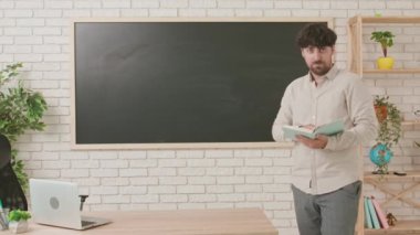 Erkek öğretmen tebeşir tahtası önünde bir sınıfta ders veriyor. Bir adam öğrencilere bilgi veriyor. Eğitim anlayışı, okulda ya da üniversitede öğretmenlik. Eylül, derslerin başlangıcı