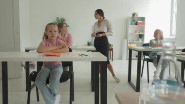 Bir grup ilkokul öğrencisi fen bilgisi öğreniyor. Ortaokul öğrencileri fen bilimleri kimyası dersinde. Öğretmen çocuklarla konuşur, sorular sorar ve dersi tartışır. Yavaş çekim.