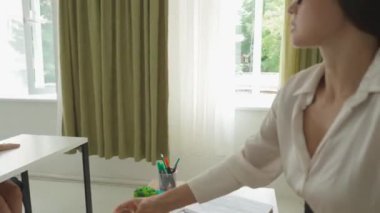 Bir grup ilkokul öğrencisi fen bilgisi öğreniyor. Ortaokul öğrencileri fen kimyası dersinde sınıfta otururlar. Öğretmen elinde yeşil sıvıyla cam tüp tutuyor. Dersi açıklıyor. Modern eğitim kavramı.