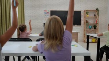 Bir grup ilkokul öğrencisi. Sınıftaki ortaokul öğrencileri, kadın öğretmenler çocuklara ders veriyor, çocukları görev için tahtaya çağırıyorlar. İlkokul.