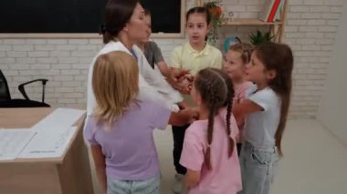Bir grup ilkokul öğrencisi. Sınıftaki ortaokul öğrencileri, birlikte tezahürat yapan kadın öğretmen ve çocuklar, takım çalışması ve sınıf arkadaşlarıyla kaynaşma. , İlköğretim.