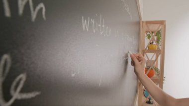 Bayan öğretmenin elinde tebeşir var. Karatahtaya kadın el yazısı metni ve formüllerini kapatın. Profesör tahtaya ya da öğrenci çözme görevine yazıyor. Eğitim ve bilim konsepti.