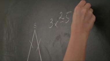 Bayan öğretmenin elinde tebeşir var. Karatahtaya kadın el yazısı ve trigonometri formüllerini kapatın, profesör tahtaya ya da öğrenci çözme görevine yazıyor. Eğitim ve bilim konsepti.