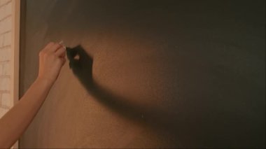 Bayan öğretmenin elinde tebeşir var. Karatahtaya kadın el yazısı formüllerini kapat, profesör tahtaya ya da öğrenci çözme görevine yazıyor. Eğitim ve bilim konsepti.