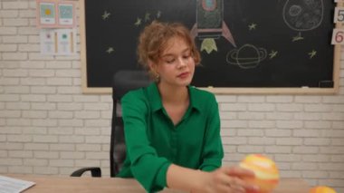 Bir grup ilkokul öğrencisi sınıfta fen bilgisi öğreniyor. Ortaokul öğrencileri ve kızlar astronomi sınıfında oturuyor. Bayan öğretmen gezegen modelini elinde tutuyor ve bunu çocuklara açıklıyor. Modern eğitim kavramı