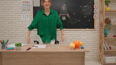 Bir grup ilkokul öğrencisi sınıfta fen bilgisi öğreniyor. Ortaokul öğrencileri ve kızlar astronomi sınıfında oturuyor. Çocuklar bayan öğretmene koşup birbirlerine sarılırlar. Modern eğitim kavramı.