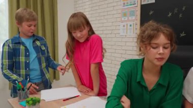 Bir grup ilkokul öğrencisi sınıfta fen bilgisi öğreniyor. Ortaokul öğrencileri ve kızlar astronomi sınıfında oturuyor. Bayan öğretmen çocuklara gezegen modelleri veriyor ve açıklıyor. Modern eğitim kavramı.