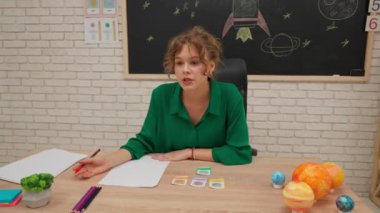 Bir grup ilkokul öğrencisi sınıfta fen bilgisi öğreniyor. Ortaokul öğrencileri ve kızlar astronomi sınıfında oturuyor. Bayan öğretmen görevleri kontrol ediyor ve çocuklara kötü geri bildirim veriyor. Modern eğitim kavramı.
