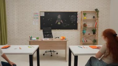 Bir grup ilkokul öğrencisi sınıfta fen bilgisi öğreniyor. Ortaokul öğrencileri ve kızlar astronomi sınıfında oturuyor. Bayan öğretmen sınıfa girerken çocuklar eğleniyor. Modern eğitim kavramı.