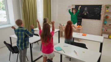 Bir grup ilkokul öğrencisi sınıfta fen bilgisi öğreniyor. Ortaokul öğrencileri ve kızlar astronomi sınıfında oturuyor. Bayan öğretmen ve çocuklar ısınma egzersizleri yapıyorlar. Modern eğitim kavramı.