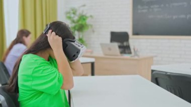 Fütüristik bir sınıf ortamında, VR kulaklık takan bir öğrenci virüslerin 3 boyutlu görselleştirmesiyle etkileşime geçerek sanal gerçekliğin nasıl kullanıldığını gösteriyor..