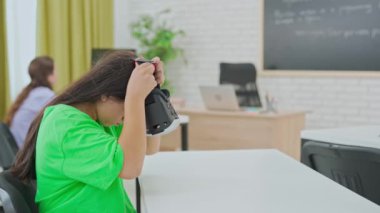 Öğrenci, insan beyninin detaylı bir üç boyutlu modelini keşfetmek ve etkileşim kurmak için sanal gerçeklik kulaklığı kullanıyor. Modern bir sınıftaki eğitici deneyimler için VR kullanımını gözler önüne seriyor.