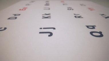 Harfleri net bir odak noktasında basit bir tasarım ile gösteren bir alfabe posterinin yakın çekimi. Anaokulu ya da kıdemsiz okuma grubu afişi, gelişim faaliyetleri konsepti.