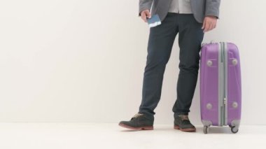 Havaalanı koridorunda bagajlı bir gezgin. Pasaport biletleri ve bavullarıyla seyahat eden turist, beyaz arka planda izole bir şekilde uluslararası havaalanında yürüyor. Seyahat kavramı