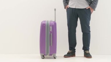 Havaalanı koridorunda bagajlı bir gezgin. Seyahat eden iş adamı turist, uçuşu beklerken bavulunu alıp uluslararası havaalanında izole edilmiş beyaz arka planda geziyor. Seyahat kavramı.
