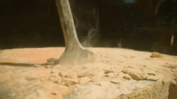 stock image Drill penetrating stony ground. Dynamic action of a hammer drill impacting a sandy surface, highlighting the dispersion of sand particles. Industrial power in action.