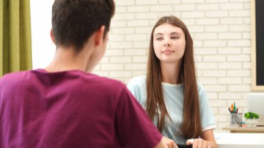 Oditoryumdaki bir grup genç kız ve erkek öğrenci. Sınıftaki liseli gençler sıralarında oturup sınav yazıyorlar, kız ve erkek sınavı bitirip, konuşuyorlar ve ara veriyorlar. Modern eğitim kavramı.