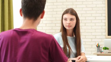 Oditoryumdaki bir grup genç kız ve erkek öğrenci. Sınıftaki liseli gençler sıralarında oturup sınav yazıyorlar, kız ve erkek sınavı bitirip, konuşuyorlar ve ara veriyorlar. Modern eğitim kavramı.