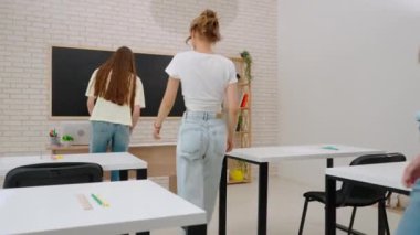 Oditoryumdaki bir grup genç kız ve erkek öğrenci. Sınıftaki liseli gençler, öğretmenler masasından sınav kağıtlarını alıyorlar, sınava hazırlanıyorlar. Modern eğitim kavramı.