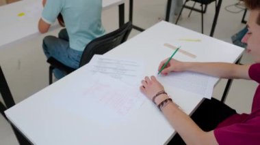 Oditoryumdaki bir grup genç kız ve erkek öğrenci. Sınıftaki liseli gençler test yapıyorlar, sınav yazıyorlar soruları cevaplıyorlar. Modern eğitim kavramı.