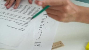 Oditoryumdaki bir grup genç kız ve erkek öğrenci. Sınıftaki liseli gençler, sınav kâğıdının yakın çekimleri, cevapları kalemle yazan kız. Modern eğitim kavramı.