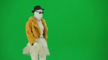 Cadılar Bayramı ve tuhaf reklam yaratıcı konsepti. Krom anahtar yeşil ekran arka planında mumya bandajlı birinin portresi. Kürk giymiş ve gözlük takmış annem podyumda yürüyor..