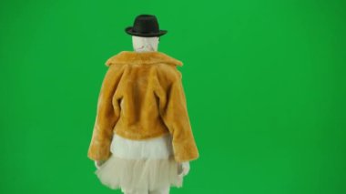 Cadılar Bayramı ve tuhaf reklam yaratıcı konsepti. Krom anahtar yeşil ekran arka planında mumya bandajlı birinin portresi. Kürk giymiş ve gözlük takmış annem podyumda yürüyor.