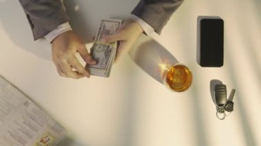 En tepedeki adam bizden bir tomar para sayıyor, banknotlara bakıyor, faturalara bakıyor, kredi olarak para alıyor ya da borç alıyor. Nakit ödeme ile hizmet veya ürün için ödeme yapan erkek.