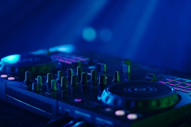 Neon mavi ışıklarla yıkanmış bir DJ 'in yakın çekimi.