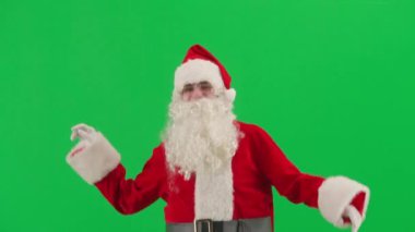 Noel ve Yeni Yıl yaratıcı konsepti. Krom anahtar yeşil ekranda Noel Baba kılığında bir adam portresi. Kırmızı elbiseli Noel Baba komik dans ediyor..